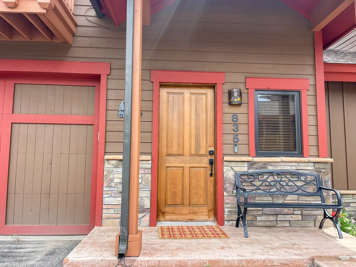 This inviting exterior shot shows the villa's front door, a bench for relaxing, and house numbers clearly visible. It exudes a welcoming atmosphere, suggesting easy comings and goings for families embarking on or returning from outings.